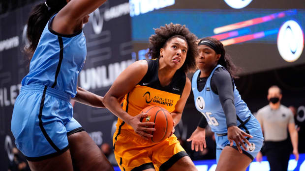 Team Mitchell guard forward Tianna Hawkins drives the ball with two defenders on her